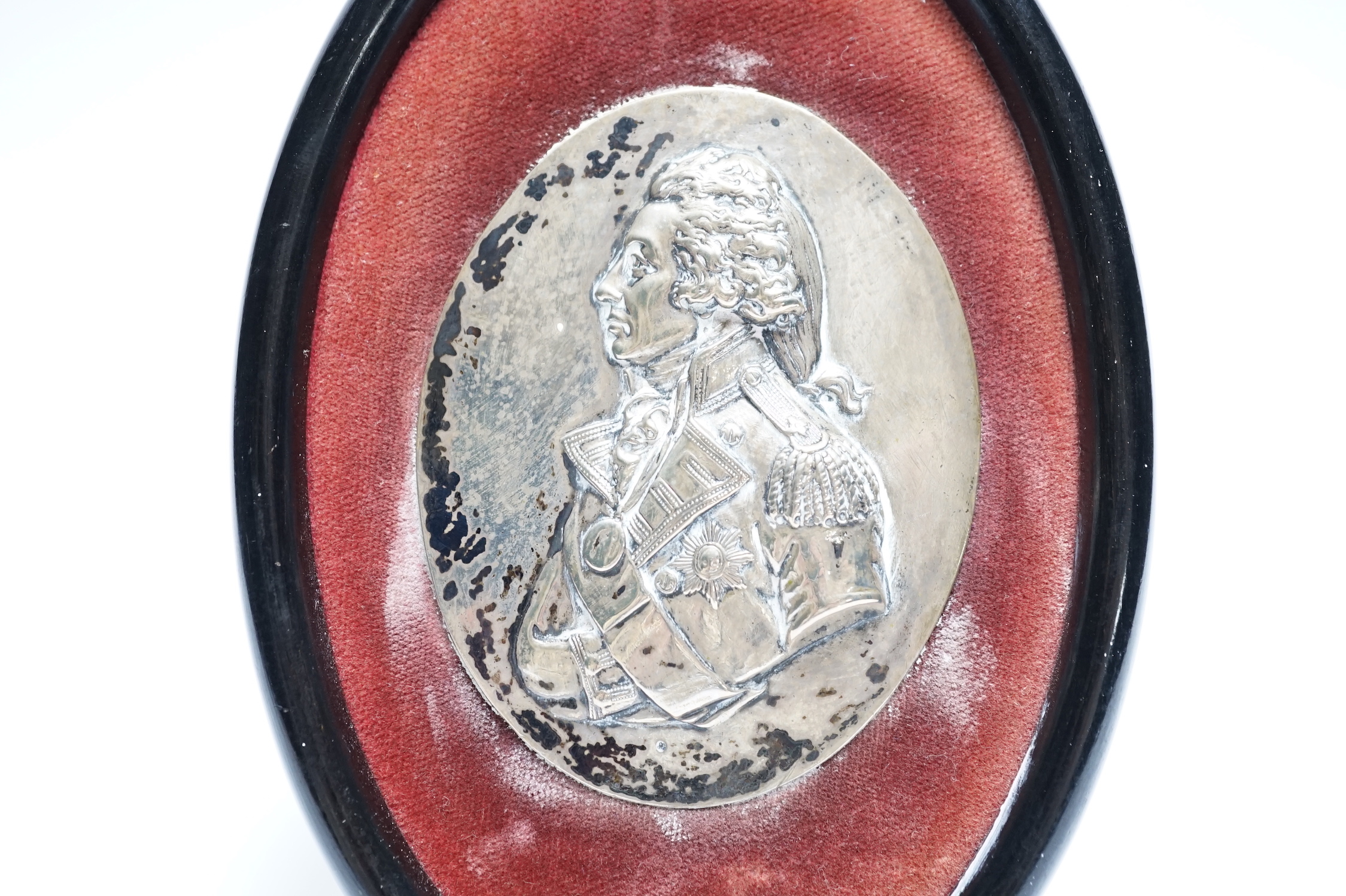 A small framed white metal oval plaque, modelled as a bust of Lord Nelson in relief, 86mm by 67mm.